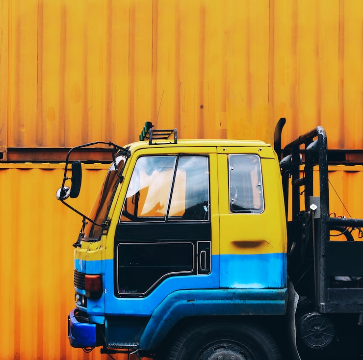 yellow-truck-parked-near-yellow-container-box_53876-64702